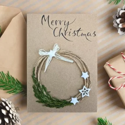 Handmade Merry Christmas card with twine and green festive wreath adorned with white star embellishments.
