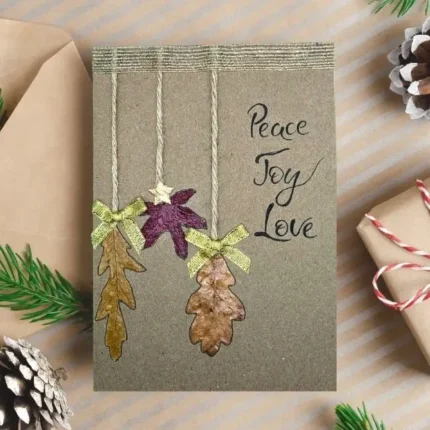 Best Handmade Personalised Warm Christmas Card made of three oblong dry leaves, fasteive bows and star.