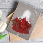 A beautifully crafted best romantic birthday card for her birthday with a girl in a red dress, decorated with dry leaves and feathers for a romantic theme.
