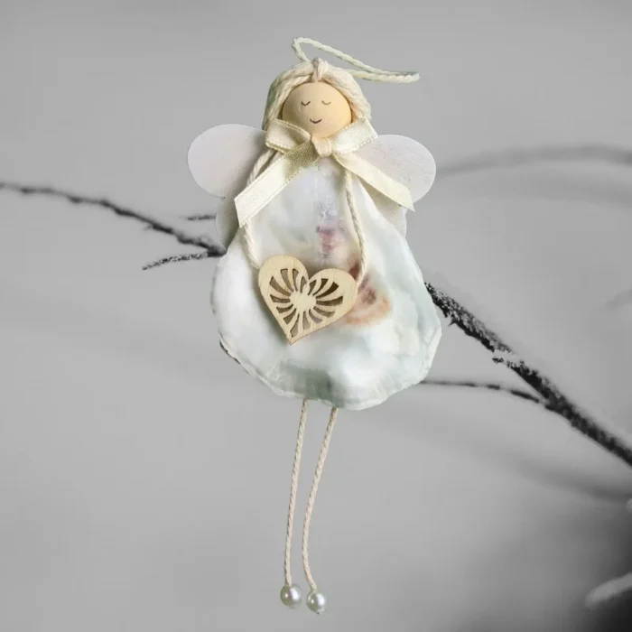 Handmade Seashell Christmas Ornament made of white seashell, wooden heart and wings.