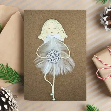 Personalised and Unique Handmade Christmas card for wife featuring a girl made of a white feather, holding a wooden snowflake.