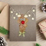 Handmade funny Christmas card for Family with reindeer made of dried leaves and pistachios.