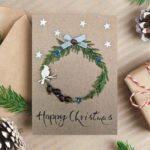 Personalised Handmade Christmas card on brown paper, with festive wreath, silver ribbon bow and bird.
