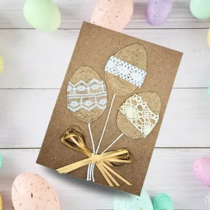 Handmade Easter card featuring a flower bouquet made of colourful Easter eggs, adorned with lace and ribbon on a white background.