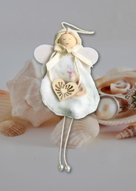 The handmade shell angel ornament features a white angel made of seashell with a heart, which is part of a unique collection for gifts and decor.