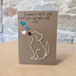 A handmade unique birthday card for dog lovers with a graphic depicting a dog on a string, standing on a table.