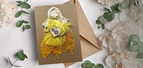 Handmade card for her featuring a yellow women made of yellow feathers, positioned in the top right corner of a banner.