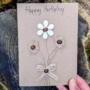 A birthday card with a decorative flower and bow, uniquely handmade by Heart in Creation.