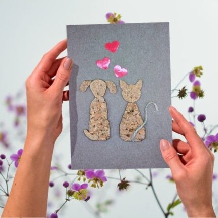 Handmade Dog and Cat Valentines Card - A close-up of the eco-friendly card held in hands, showing the detailed cork figures and hearts.